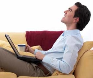 Man Working On Computer On Couch Picture