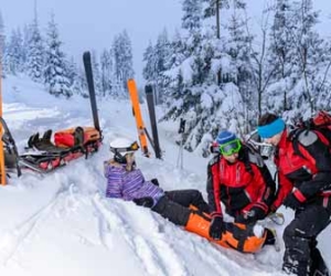 Two Ski Patrollers Assist Woman With Broken Leg Picture