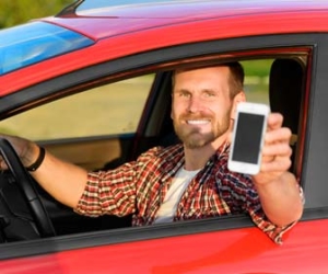 Man drives car with smartphone out window for shared economy jobs