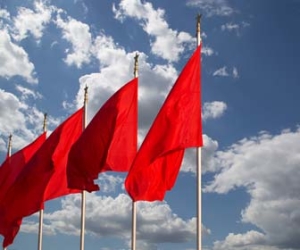 Red flags against clouds and blue skies