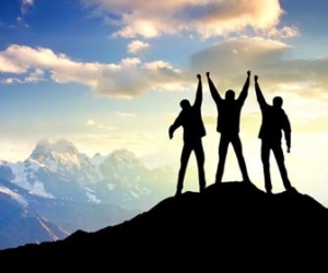 People celebrate success at top of mountain