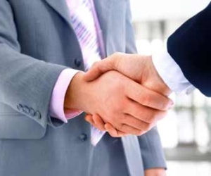 Close up of business men in suits shaking hands.