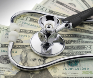 Physician's stehtoscope laying on top of $20 bills image
