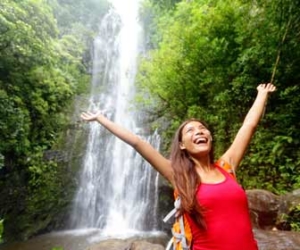 Woman excited to see a natural waterfall on ecotourism trip image