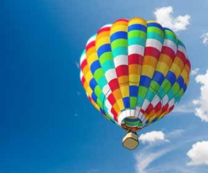 Colorful hot air balloon flying against blue skies