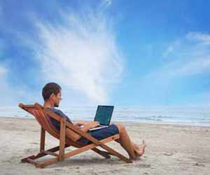 Day Trader Trades Stocks on Laptop while at Beach