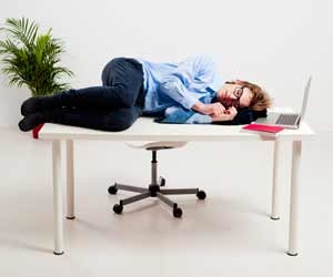 Toxic employee asleep on top of desk while at work