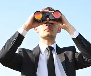 Job seeker in suit using binoculars to find a job