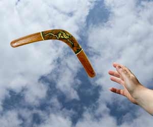 Hand throwing a boomerang against a cloudy sky