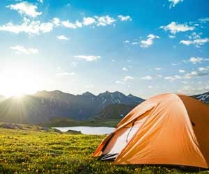 Tent set up in remote mountains near lake that is completely off the grid