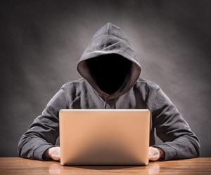Hacker without face working on laptop