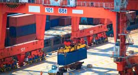 Longshoreman Operates Crane to Unload Cargo Ship at Port