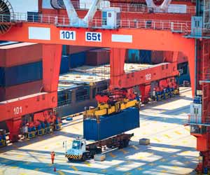 Longshoreman Operates Crane to Unload Cargo Ship at Port