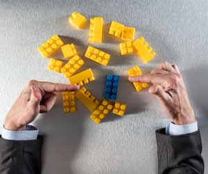 Hands sorting and pointing at a variety of yellow and blue Legos