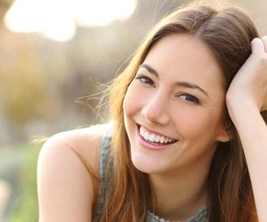 Likeable woman is smiling at camera and showing her teeth