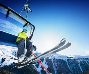 Skier sitting on chairlift with safety bar down