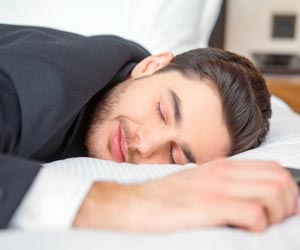Man in suit sound asleep on cozy bed