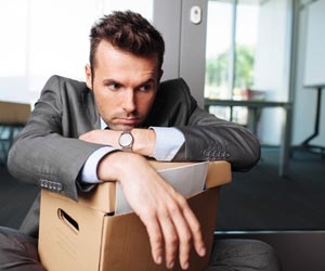 Young professional with box of stuff after getting fired