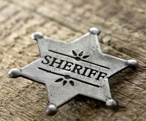 Sheriff's badge sitting on wooden table